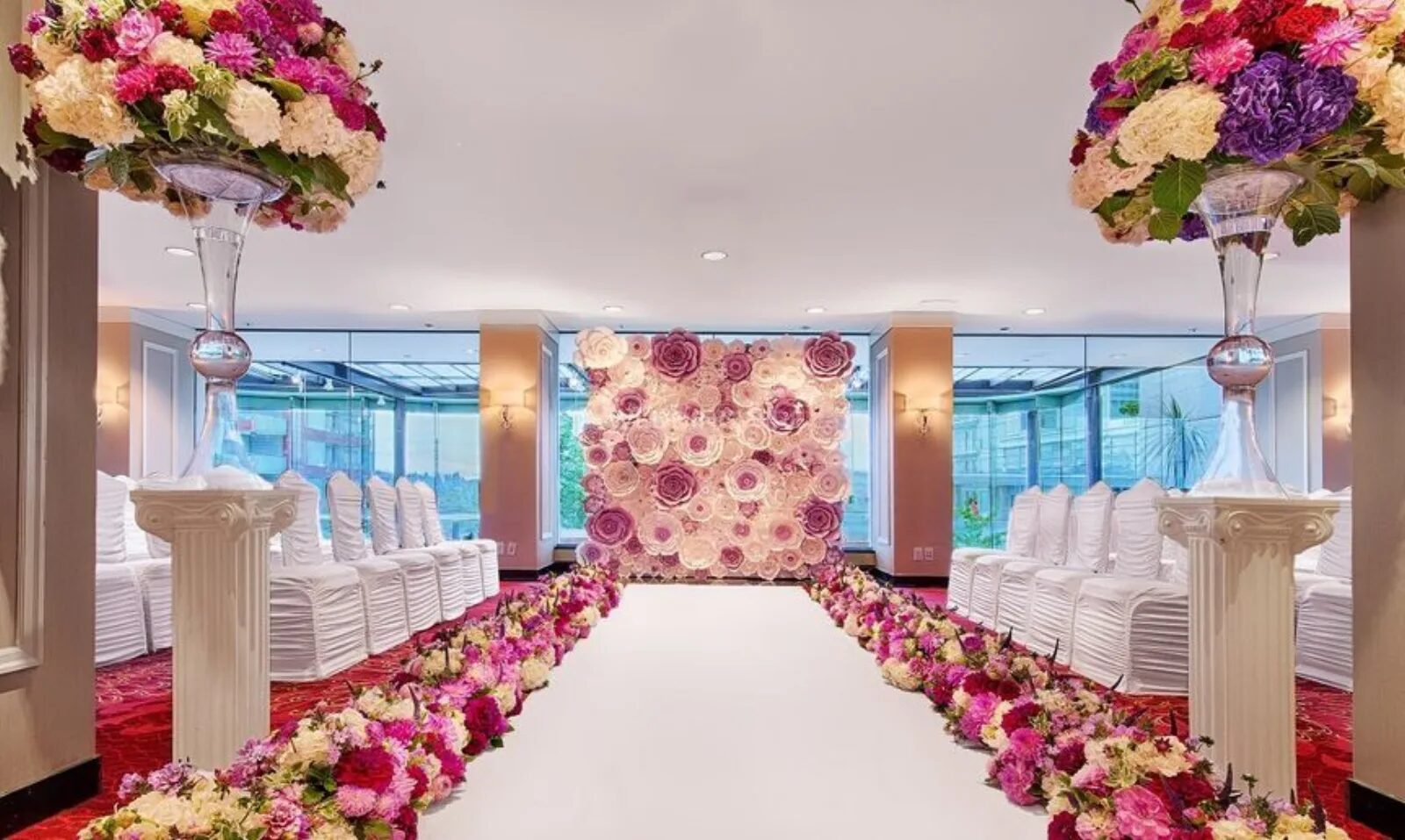 Wedding ceremony with a floral backdrop and petal-lined aisle at Pinnacle Hotel Harbourfront